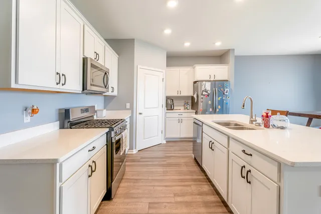a kitchen with white cabinets and appliances