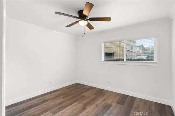a view of a room with wooden floor and a ceiling fan