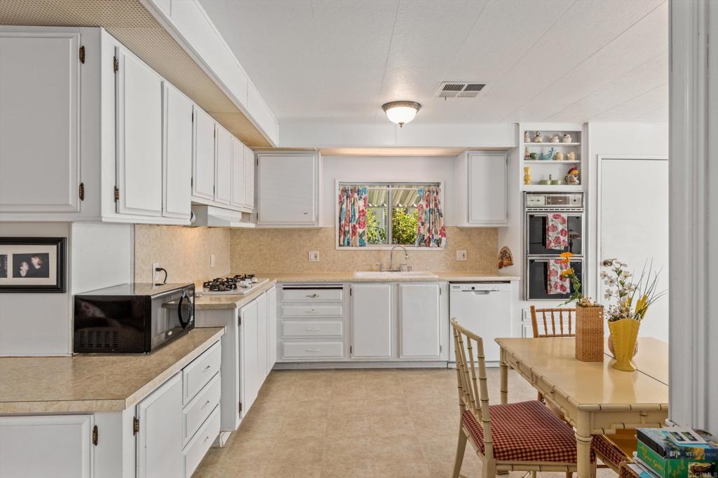 650 South Rancho Santa Fe Road, Unit 256 San Marcos, CA 92078 - Photo 13 of 60 a kitchen with stainless steel appliances kitchen island granite countertop a sink and cabinets
