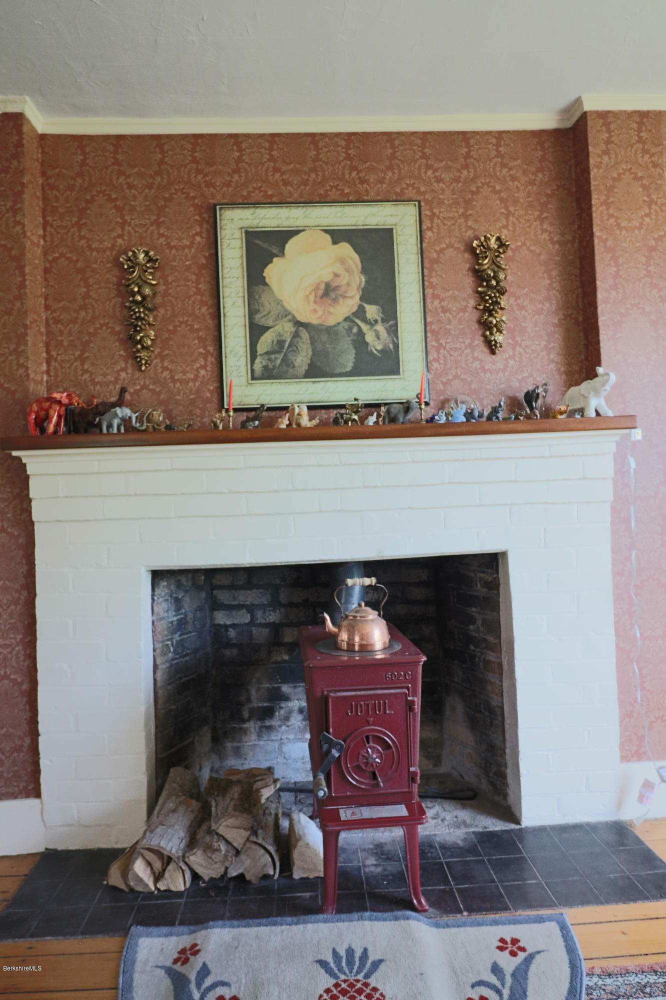22 Summit Road Richmond, MA 01254 - Photo 12 of 52 a fireplace with a vase of flowers on top of it