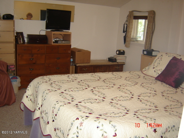1091 Deeringhoff Road Moxee, WA 98936 - Photo 5 of 12 a bedroom with a bed and flat screen tv