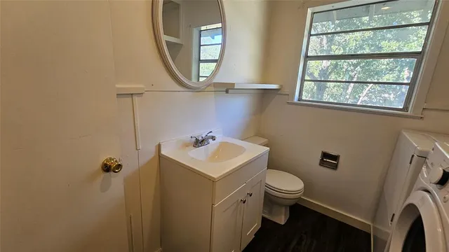 a bathroom with a sink toilet and a mirror