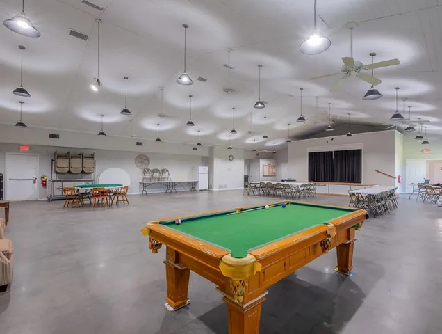 a room with pool table and windows