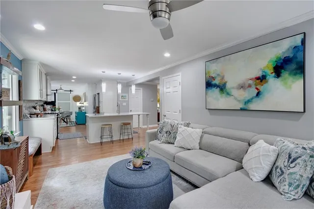 a living room with furniture and a view of kitchen