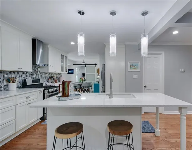 a kitchen with stainless steel appliances a sink a stove a refrigerator and cabinets