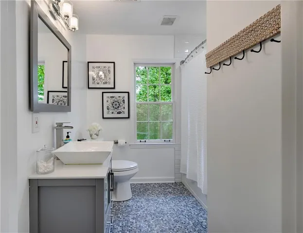 a bathroom with a sink a toilet and a window