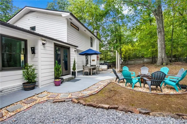 a view of a chair and table in backyard of the house