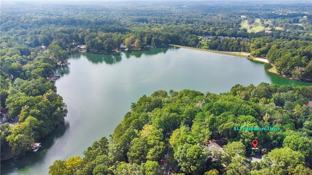 an aerial view of a house with a yard and lake view