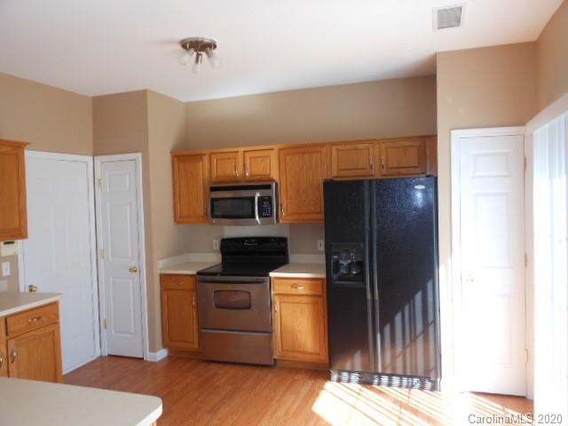 14018 Dingess Road Charlotte, NC 28273 - Photo 3 of 14 a kitchen with a refrigerator and a stove top oven
