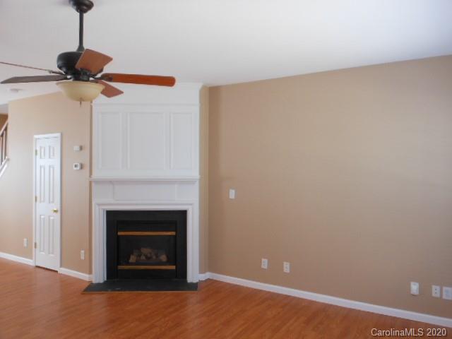 14018 Dingess Road Charlotte, NC 28273 - Photo 5 of 14 a view of a livingroom with a fireplace and a chandelier fan