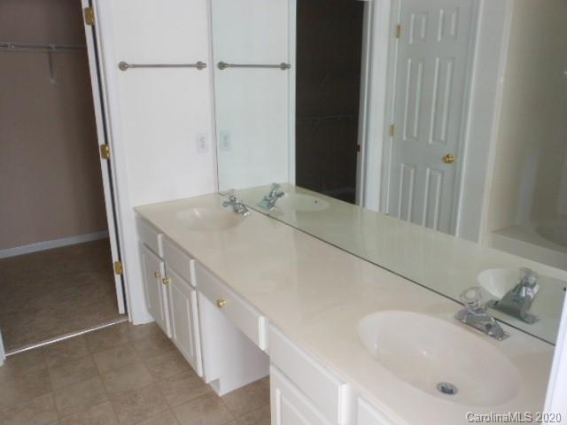 14018 Dingess Road Charlotte, NC 28273 - Photo 10 of 14 a bathroom with a sink and a mirror
