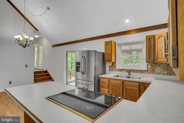 a kitchen with stainless steel appliances granite countertop a sink a stove and a refrigerator