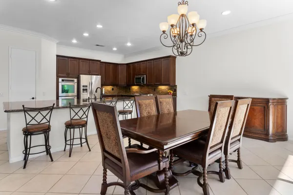 a view of a dining room with furniture a chandelier and wooden floor