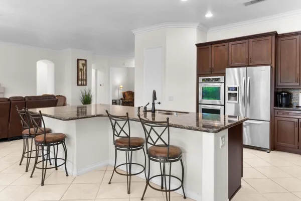 a kitchen with stainless steel appliances kitchen island granite countertop a refrigerator and a stove top oven