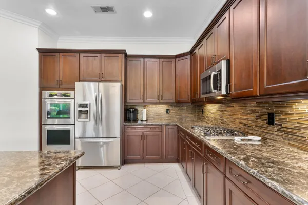 a kitchen with stainless steel appliances granite countertop a refrigerator sink and cabinets