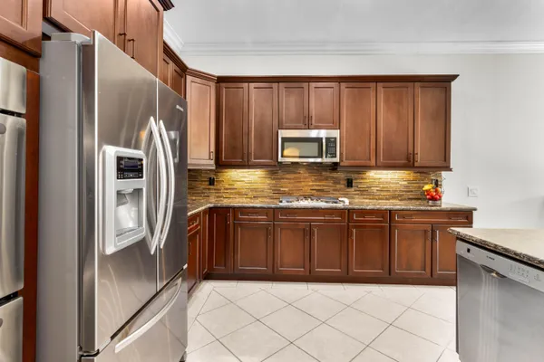 a kitchen with stainless steel appliances granite countertop a refrigerator a stove a sink and dishwasher