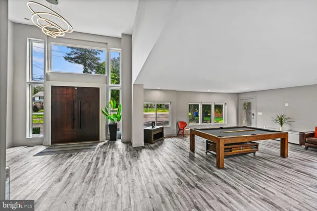 a large kitchen with stainless steel appliances kitchen island granite countertop a large kitchen island a stove a refrigerator a sink a dining table and chairs with wooden floor