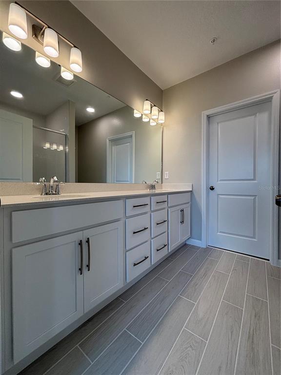 660 Pothos Street Apopka, FL 32703 - Photo 20 of 32 a spacious bathroom with a double vanity sink and a mirror