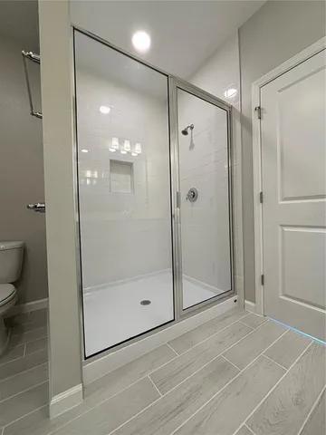 a bathroom with a shower and a glass door