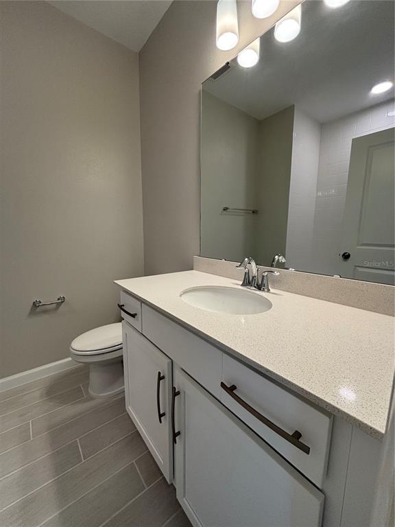 660 Pothos Street Apopka, FL 32703 - Photo 24 of 32 a bathroom with a granite countertop sink a toilet and a mirror