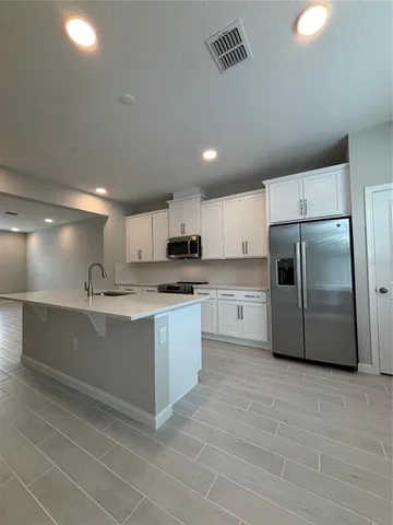 a large kitchen with cabinets and stainless steel appliances