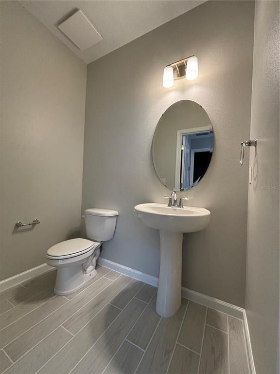 660 Pothos Street Apopka, FL 32703 - Photo 8 of 32 a bathroom with a toilet sink and mirror