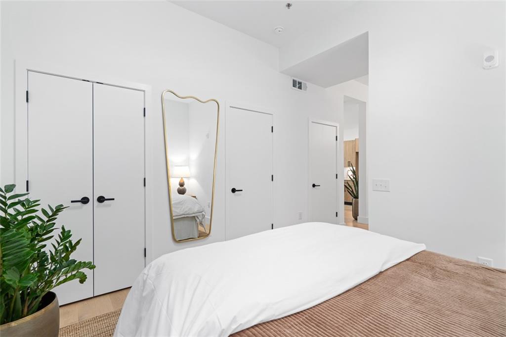 567 Ponce De Leon Avenue Northeast, Unit 516 Atlanta, GA 30308 - Photo 14 of 45 a bedroom with a bed and a potted plant