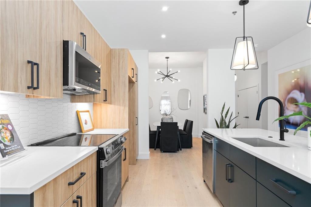 567 Ponce De Leon Avenue Northeast, Unit 516 Atlanta, GA 30308 - Photo 9 of 45 a kitchen with a sink and a stove top oven with wooden floor