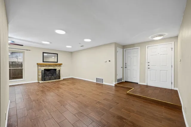 a view of an empty room with a fireplace and a window