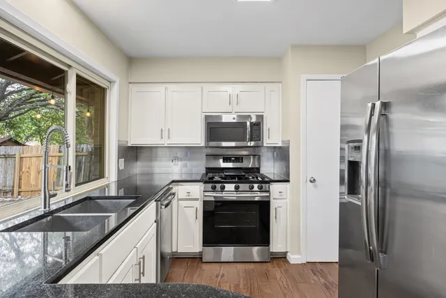 a kitchen with a stove a refrigerator and a sink