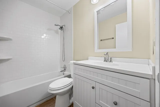 a bathroom with a granite countertop toilet sink and mirror