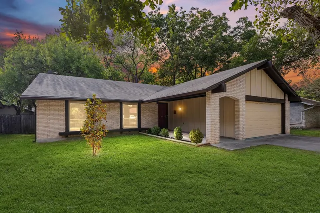 a view of a house with a yard and a garage