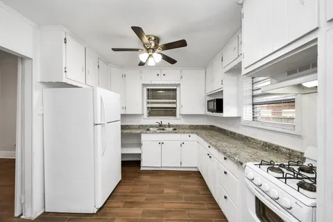 a kitchen with white cabinets and appliances