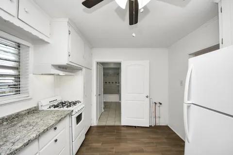 a kitchen with a refrigerator a sink and wooden floor