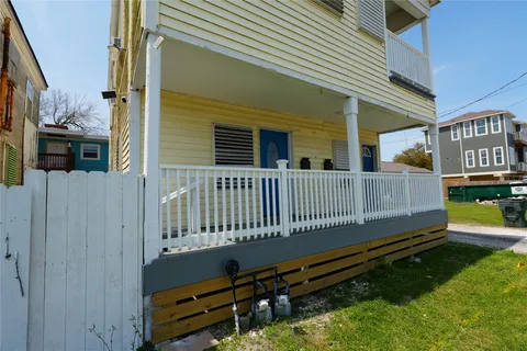 a view of a house with a small yard and wooden fence