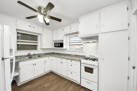 a kitchen with a stove cabinets and window