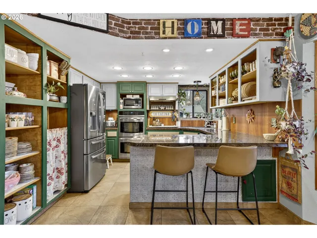 a kitchen with stainless steel appliances granite countertop a refrigerator and a stove top oven