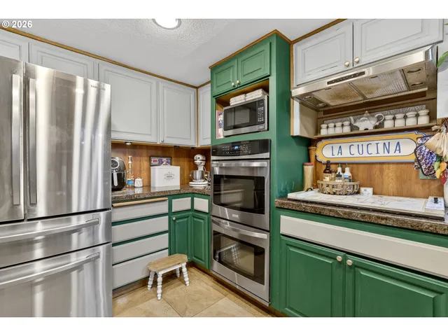 a kitchen with stainless steel appliances granite countertop a refrigerator and cabinets