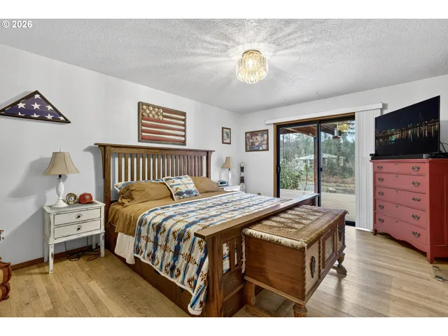 a bedroom with a bed and a flat tv screen on dresser