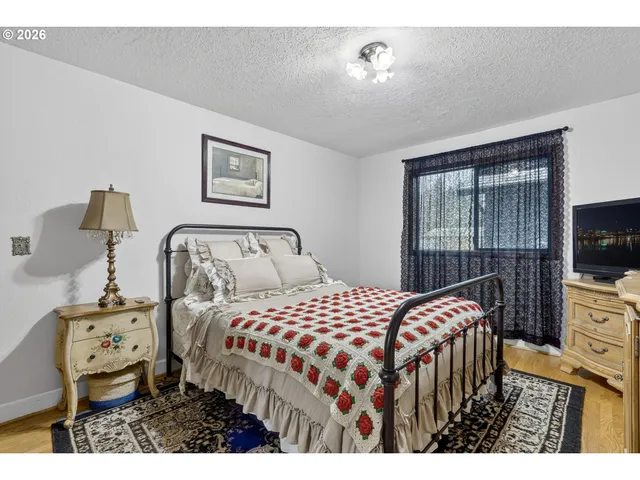 a bedroom with a bed a dresser and large mirror