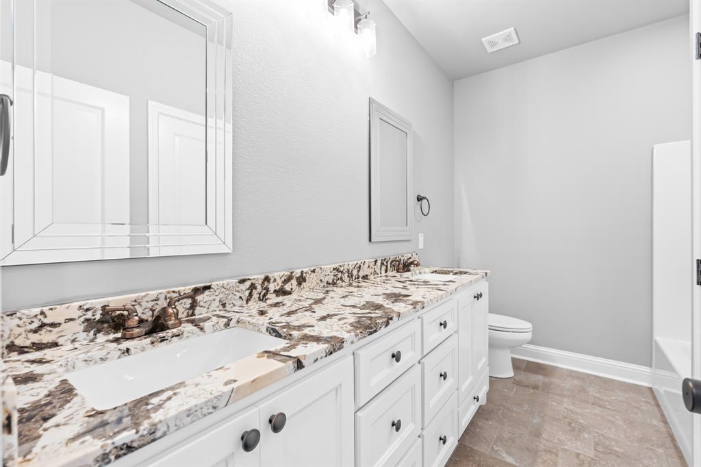 120 Water View Lane Robinson, TX 76706 - Photo 26 of 34 Hall bathroom featuring a sink, toilet, double vanity, and bathtub.