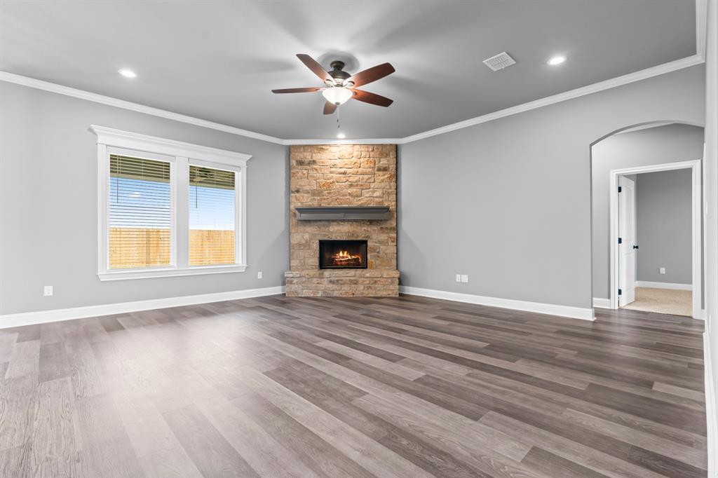 120 Water View Lane Robinson, TX 76706 - Photo 5 of 34 Living room with a stone fireplace, dark wood finished floors, visible vents, ceiling fan, and arched walkways
