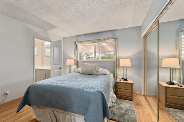a bedroom with a bed and wooden floor