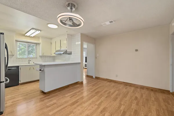 a view of a kitchen with a sink dishwasher and wooden floor