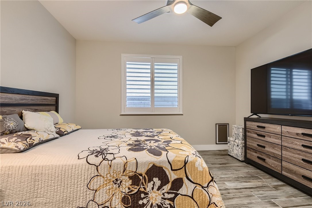 4631 Amazing View Street Las Vegas, NV 89129 - Photo 11 of 33 Well-lit sleeping quarters featuring elegant wood-look flooring and a functional ceiling fan.