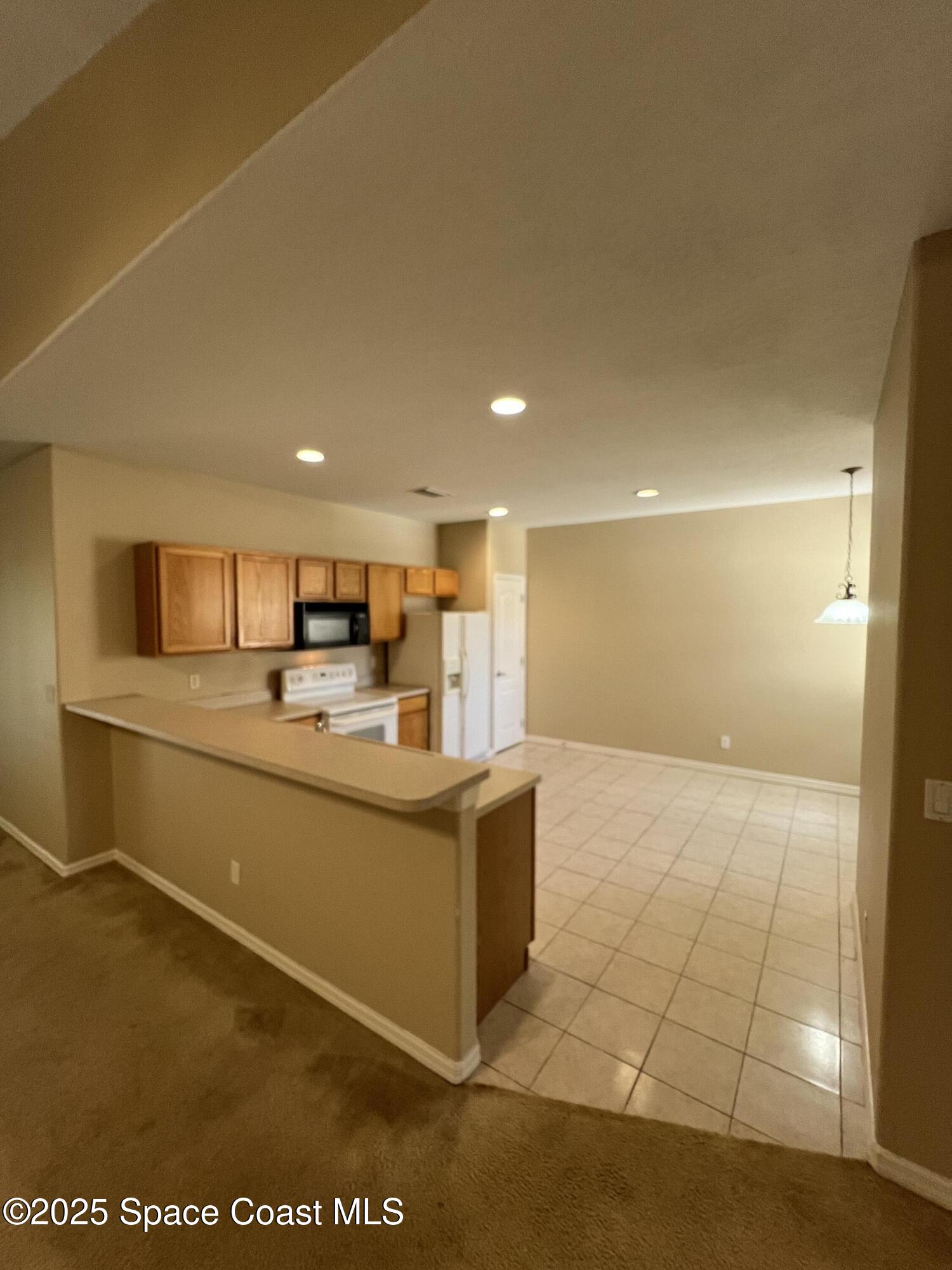 1040 Venetian Drive, Unit 203 Melbourne, FL 32904 - Photo 7 of 23 a view of kitchen with stainless steel appliances granite countertop a sink and cabinets