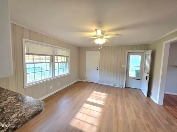 a view of a hallway with wooden floor and staircase
