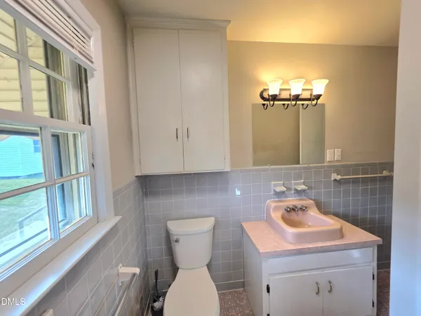 a bathroom with a sink toilet a mirror and shower