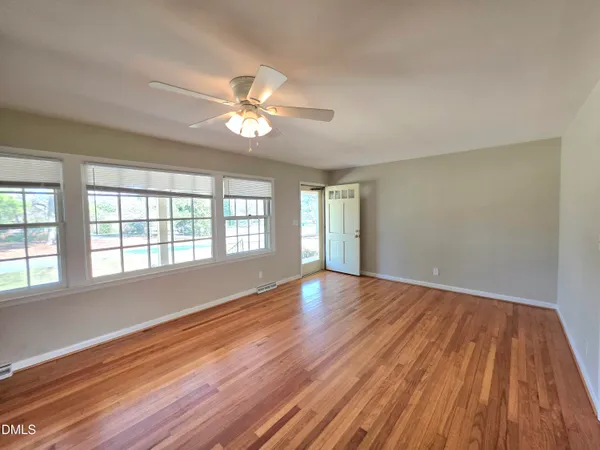 a view of empty room with wooden floor and fireplace