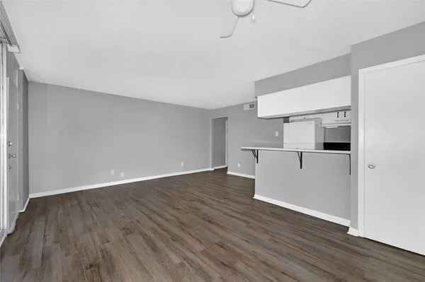 a view of a kitchen with wooden floor and electronic appliances